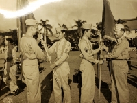 The colors of the famed 442nd Infantry Regiment and the 100th Infantry Battalion which went into many battles in Europe are once again in the Army. But this time on a reserve status. Show smilingly hold on to their colors once again after the reactivation ceremonies which has held at Ft. Shafter are, L to R, Lt. Colonel Harry Albright, Commanding Officer of the 442nd Infantry Regiment, 1st Sgt. Harry Harimoto, holding the 442nd colors, T/Sgt. Kenneth Nakamoto and Major Mitsuyoshi Fukuda holding colors of the 100th Infantry Battalion.