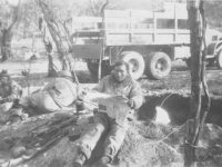 A soldier reads a newspaper outside a dugout in Italy, 1944. [Courtesy of Mary Hamasaki]