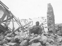 A soldier sits on rubble in Cassino, Italy, 1944. [Courtesy of Mary Hamasaki]