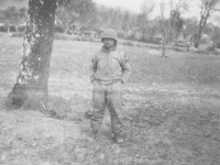 Soldier stands near a tree in camp, Italy. [Courtesy of Mary Hamasaki]