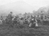 Soldiers sit on a hill and enjoy coffee and music. [Courtesy of Mary Hamasaki]