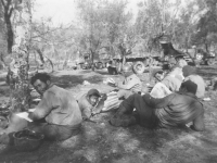Soldiers read newspapers and write letters home during some down time in Cassino. [Courtesy of Mary Hamasaki]