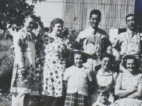 100th soldiers with aprons. Scott Hendersin family. BACK L to R: Unknown, Marie Hendersin, Unknown, Unknown, Scott Hendersin. MIDDLE L to R: JoAnne, Betty and Nancy Hendersin. FRONT: Bobby Hendersin. [Courtesy of Monroe County Local History Museum, Sparta, Wisconsin. Jarrod Roll, Director. Jan 8, 2019]