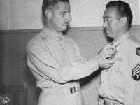 Technician 4th class Kenichi Suehiro (100th HQ) of Honolulu stands proudly as he receives his medal. [U.S. Army Signal Corps]