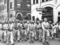 A Co. Parades in La Crosse, Wisconsin in connection with Bond sale Promotion with Abbot and Costello. Parade is led by Capt. Jack Johnson. [Courtesy of Janice Uchida Sakoda]