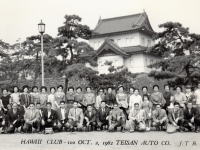 (October 02, 1962) Members of the 100th Infantry Battalion Veteran’s Club, “Club 100”, in front of the Imperial Palace in Tokyo, Japan. Eugene Kawakami was the leader for “Group I” on this Japan Trip, comprised of Company “A” and Company “C” veterans and wives. Eugene is pictured in the front row, on the far left.  [Courtesy of Joanne Kai]