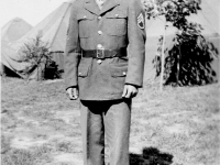 (September 1942) Eugene Kawakami posing in front of the "old camp" at Camp McCoy, Wisconsin. The men of the 100th Infantry battalion were able to move out of the tents and into military barracks at this time.  [Courtesy of Joanne Kai]