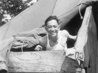 Masanobu Eugene Kawakami in tent with wooden boards for protection when it snows and rains. 8-30-42.  [Courtesy of Joanne Kai]