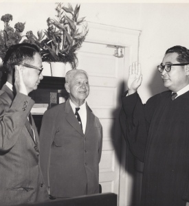 Jack Mizuha, Associate Justice of the Hawaii Supreme Court, swearing in his friend Takashi Kitaoka as the newly appointed judge for the Second Circuit Court on Maui in 1962.  The two men were both born on Maui and were original members in the 100th Infantry Battalion. [Courtesy of Takashi Kitaoka]