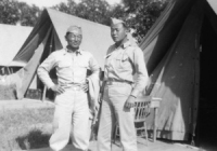 Mits Fukuda standing in front of his tent at Camp McCoy with Sparky Matsunaga [Courtesy of David Fukuda]