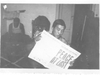 Moriso Teraoka holds up a newspaper reading "Peace at Last" on V-J day while in Leghorn, Italy, 1945 (Courtesy of Moriso Teraoka)