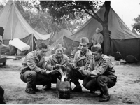 Kaoru Naito, Calvin Shimogaki, Suyeoshi and Hisashi Komori warming themselves by a fire at Camp McCoy in June 1942 [Courtesy of Fumie Hamamura]