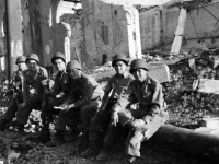 Soldiers take a rest while marching through a bombed out Italian city [Courtesy of Carol Inafuku]