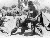 Two soldiers spar with boxing gloves in Lecco, Italy, July 1945 [Courtesy of Carol Inafuku] Inscription: Reverse: Lecco July 1945