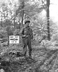 S/Sgt. James Kawashima standing guard near Co. B command post at Bruyères, France. [U.S. Army Signal Corps photo]