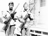 James Kawashima & Yukio Yokota standing with rifles in hand at Camp McCoy, Wisconsin [Courtesy of Alexandra Nakamura]