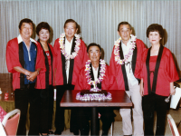 Club 100 Karaoke Kai's first anniversary celebration. Karaoke Kai Advisers and Officers [L-R] Richard “Japan” Nakahara (Vice President), Marge Toma (Treasurer), Robert “Bob” Takashige (Advisor), Masao “Stu” Yoshioka (Advisor), Robert Sakoki (Advisor), and Gladys Kawakami (President) [Missing: Janet Aoki (Secretary)]. [Courtesy of Puka Puka Parade (Apr-Jun 1984, Vol. 38 No. 2)]
