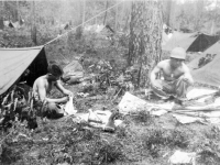 'Toro' John Kihara and 'Old Man' Tanaka cleaning their rifles in front of tents at Camp Shelby [Courtesy of Leslie Taniyama] Inscription: Louisiana April ‘43 Maneuvers “Toro” John Kihara, “Old Man”  Tanaka. both deceased