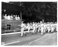 Discharged units of the famed 100th Infantry Battalion pass the reviewing stand during the Veterans Day Parade held at Kapiolani Park (V-J Day (Victory over Japan Day) Parade in Honolulu, Hawaii; August 15, 1946). [U.S. Army Signal Corps photo]