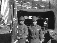 William Takaezu and fellow soldier pose with Regimental flag in Menton, France. [Courtesy of Mrs. William Takaezu]