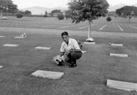 Thomas Taro Higa paying his respects to his comrade, Yasuo Kagawa (Co. E), on the 21st anniversary of his death. Kagawa was killed in action during the same battle in which Higa was wounded. (November 6, 1964) [Courtesy of: Thomas Taro Higa Family Collection]