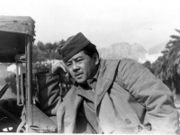 A soldier leans against a jeep [Courtesy of Ukichi Wozumi]