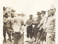 Shinyei Nakamine (far right) and other soldiers warm themselves by the fire at Camp McCoy, Wisconsin. (Courtesy of Anita Korenaga)