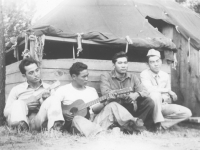 Soldiers gather around their bunks at Camp McCoy, Wisconsin to play instruments. [Courtesy of Lorraine Miyashiro]