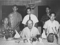 Leslie (Les), first born son of Fumi Taniyama in aloha shirt to the right of Mr. Leslie Deacon.  Appreciative 100th veterans who were fortunate recipients of Mr. Deacon's generosity met annually at M's Ranch House in Aina Haina for Deacon’s birthday.  As a tradition, all these veterans’ first born sons (ALL named Leslie) would gather around the seated patriarch for picture taking.  [Courtesy of Leslie Taniyama]